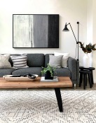 a couch with a coffee table with a plant and decor on it