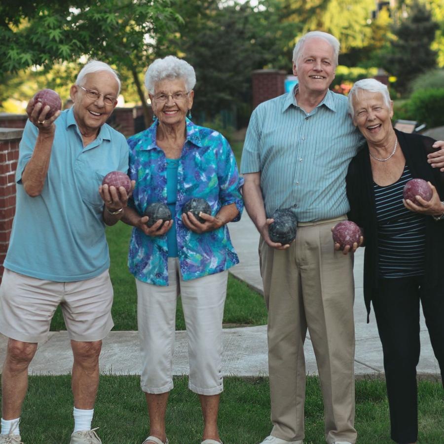 Settle into comfort at William Booth Towers a group of people playing Bocce ball